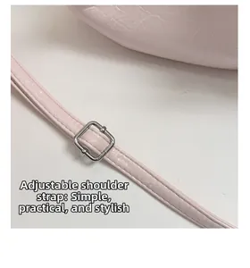 Dettaglio della tracolla regolabile in pelle rosa chiaro con fibbia in metallo argento