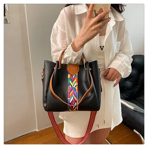 Dettaglio di una borsa tote in pelle nera opaca con strisce etniche e tracolla larga