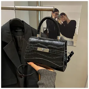 Detail of black stone pattern leather handbag with silver rotating lock and handle