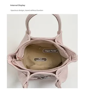 Dettaglio dell'interno del secchiello in pelle rosa chiaro con tasca principale e zip