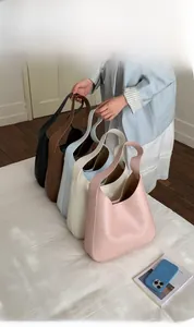 Minimalist leather bucket bag collection shown in various colors like black and brown