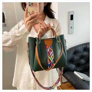 Dettaglio della borsa tote in pelle verde con tracolle etniche intrecciate e fibbie dorate