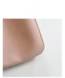 Detailed close-up of smooth stitching and soft pink leather on bucket bag base