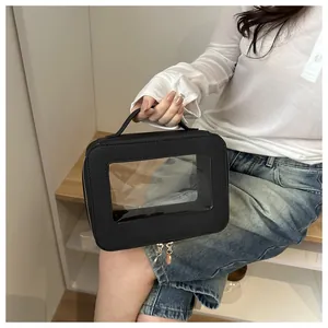 Close-up of a black travel toiletry bag with transparent window and sturdy top handle