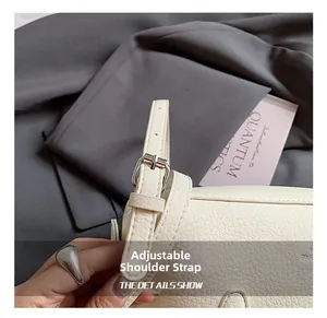 Close-up of adjustable white leather shoulder strap with silver buckle on handbag
