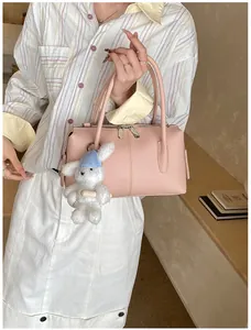 Detailed macro of pink lychee leather Boston bag with cute bunny pendant and dual zippers