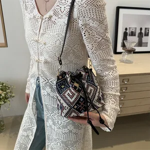 Ethnic style woven bucket bag with geometric patterns and leather drawstring closure
