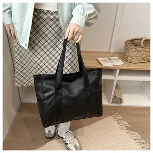 Detailansicht der Ledertextur und des großen Fassungsvermögens dieser schwarzen Shopper Tasche