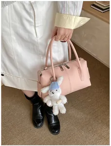 Pink lychee grain leather handbag detail with silver zippers and cute bunny pendant