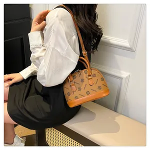 Detailansicht der Muscheltasche mit Vintage-Monogramm-Muster und brauner Einfassung