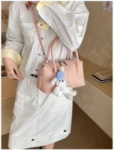 Pink lychee grain boston bag for women with cute white plush bunny charm on long strap
