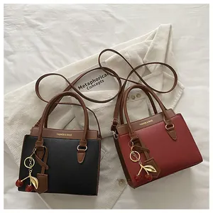 Sacs à main en cuir grainé noir et bordeaux avec pendentifs cerises et détails dorés