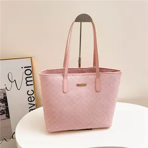 Pink tote bag with M-letter jacquard texture and golden brand plaque on display