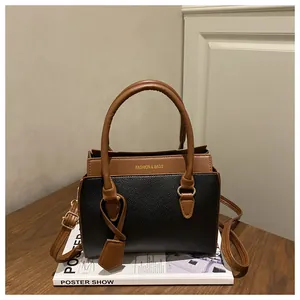 Détail du cuir grainé litchi et design bicolore contrasté sur ce sac à main de luxe