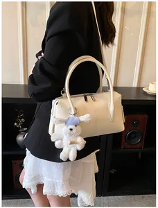 Close-up of white lychee textured tote bag with cute plush bunny charm and shoulder strap