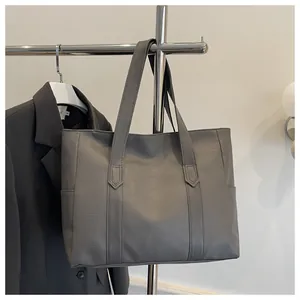 Nahaufnahme der grauen Lederstruktur und Seitentasche dieser großen Shopper-Tasche