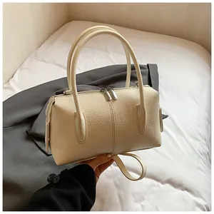 Detail of lychee textured leather boston bag in creamy white with silver zippers