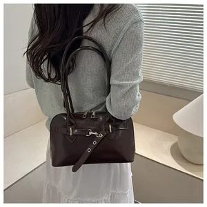 Nahaufnahme einer glänzenden dunkelbraunen Muscheltasche mit Schnallen im Wohnbereich