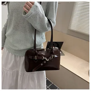 Detailansicht der dunkelbraunen glänzenden Ledertasche mit FASHION-Prägung und Goldhaken