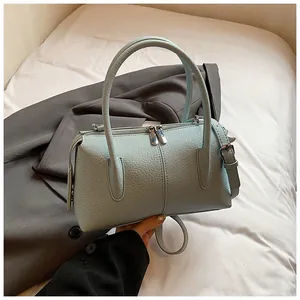 Detail of light blue lychee pattern leather handbag with silver hardware and dual straps