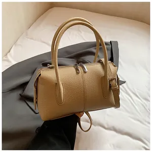 Detail of apricot lychee pattern leather Boston bag with silver hardware and dual zippers