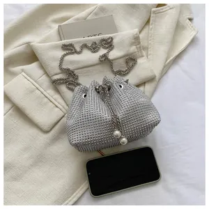 Detail of silver rhinestone bucket bag with pearl drawstring and metal chain strap
