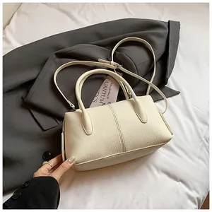 Detail of creamy lychee grain leather handbag with adjustable strap and vertical stitching