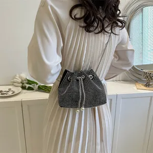 Detail of black drawstring bucket bag with shiny rhinestones and pearl accents