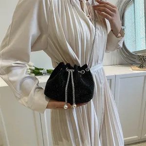Chic black rhinestone bucket bag with silver chain strap and pearl drawstring details