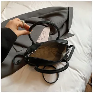 Internal structure of black litchi leather handbag with light fabric lining and silver hardware