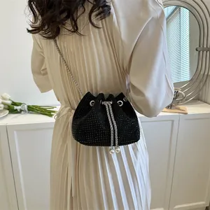 Detail of black rhinestone bucket bag with drawstring closure and elegant pearl charms