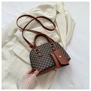 Close-up of retro shell handbag with geometric patterns and a mini matching pouch