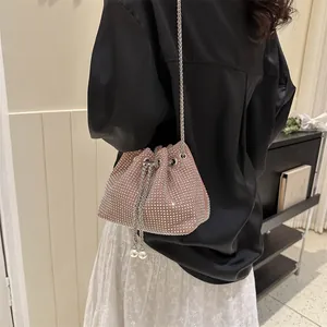 Detail of pink rhinestone bucket bag featuring drawstring chain and pearl embellishments