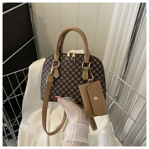 Detail of vintage brown shell bag with monogram pattern and matching mini charm pendant