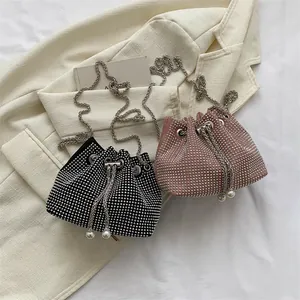 Detail of rhinestone bucket bags in black and pink with pearl drawstring and chain strap