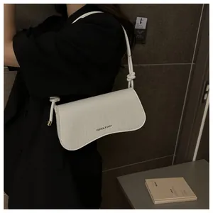Close-up of white crocodile pattern shoulder bag with FASHION & BAGS metal text logo