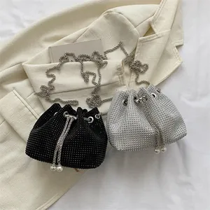 Detailed macro view of rhinestone bucket bags with drawstring pearl tassels and silver chains