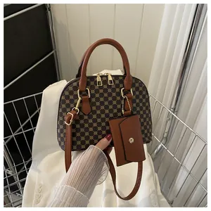 Vintage shell-shaped handbag with golden geometric patterns and brown leather straps