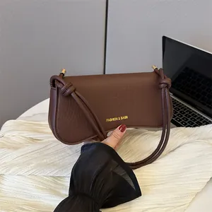 Dark brown faux leather underarm bag with crocodile pattern and knotted shoulder strap