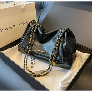 Chic black underarm bag with gold chain and hardware presented in a luxury gift box