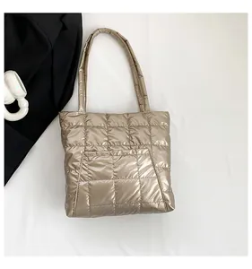 Detail of champagne gold quilted tote bag with square stitching and front pocket