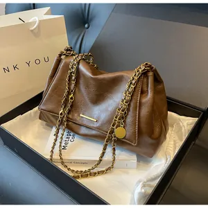 Unboxing dark brown leather chain bag with gold hardware in a premium gift box