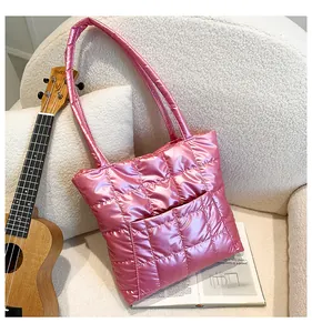 Detail of pink metallic quilted tote bag on white fleece sofa with modern grid stitching