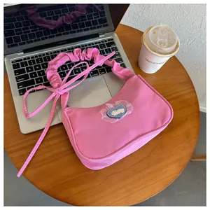 Vue détaillée du sac à bandoulière rose avec écusson lapin et bordure en tulle