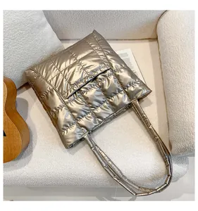 Detail of champagne gold quilted tote bag with metallic finish and front pocket