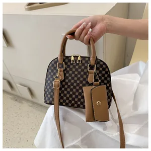 Detail view of vintage shell handbag with brown monogram pattern and khaki adjustable strap