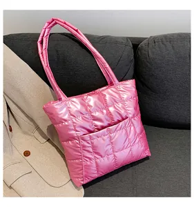 Macro shot of bright pink quilted puffer tote bag with square stitching and glossy texture