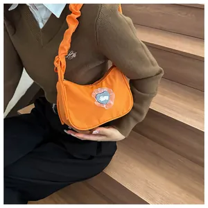Sac hobo orange avec poignée plissée et détail de patch lapin cœur brodé