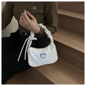 Détail du sac à épaule plissé blanc avec écusson lapin cœur et nœud latéral