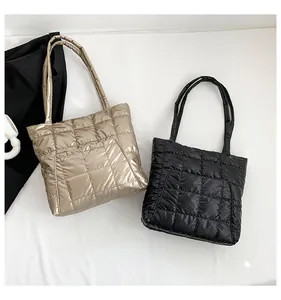 Detail of quilted tote bags in black and champagne gold with square stitching pattern